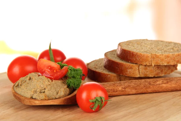 Склад свіжого паштету, помідорів і хліба на яскравому фоні — стокове фото