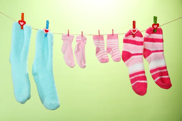 Colorful socks hanging on clothesline, on color background — Stock Photo, Image