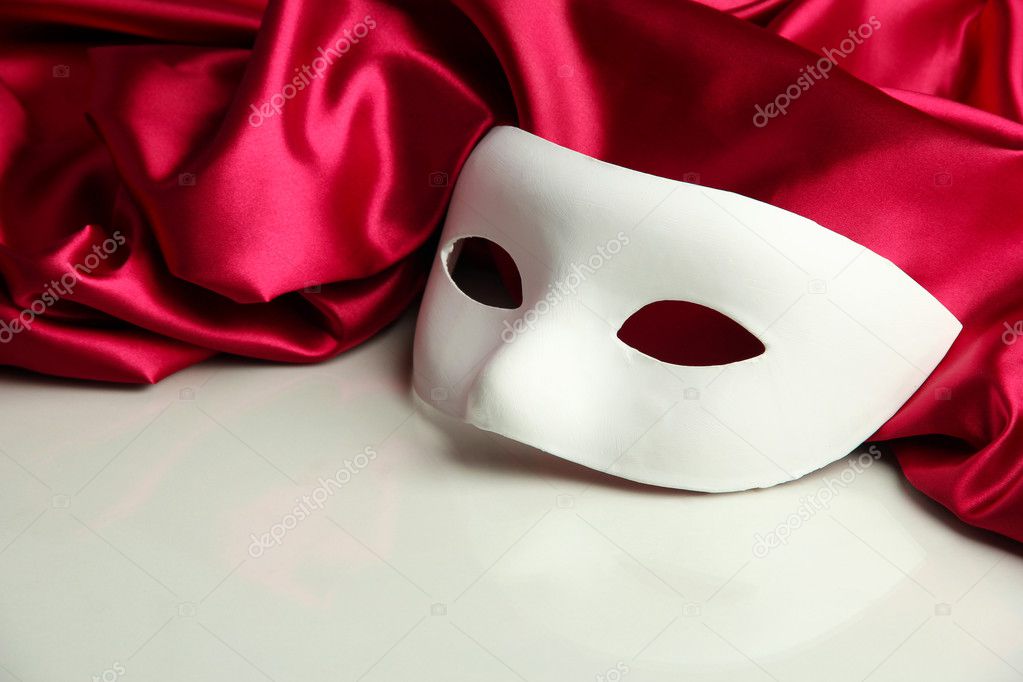 White mask and red silk fabric, isolated on white