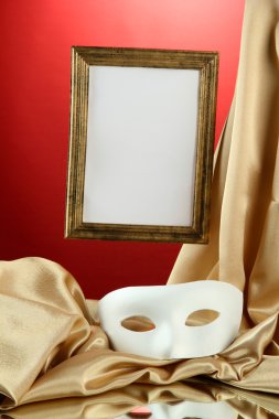 Beyaz maske, boş çerçeve ve kırmızı zemin üzerine altın ipek kumaş