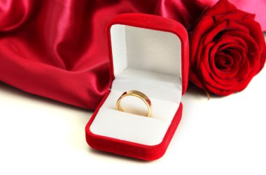 Beautiful box with wedding ring and rose on red silk background clipart