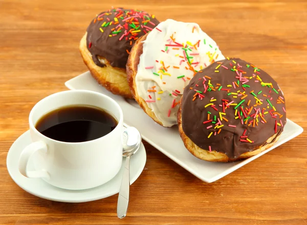 Leckere Donuts auf Farbteller auf Holzgrund — Stockfoto