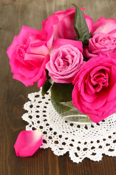 Hermosas rosas rosadas en jarrón en la mesa de madera de cerca — Foto de Stock