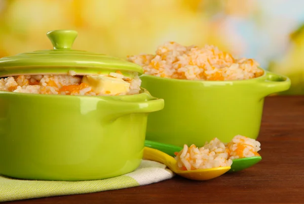 Mingau de arroz com abóbora em panelas na mesa de madeira, no fundo verde — Fotografia de Stock