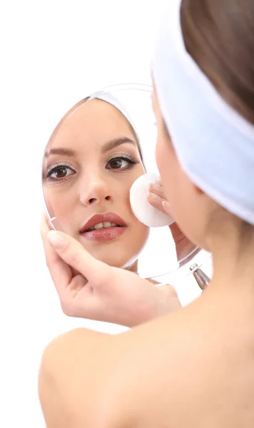 Giovane donna che pulisce il viso, isolata su bianco — Foto Stock