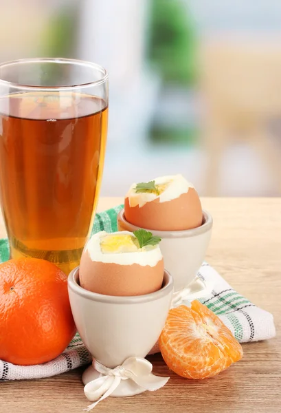 Lätt frukost med kokt ägg och ett glas juice på träbord i café — Stockfoto