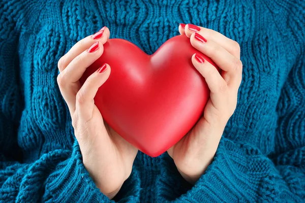 Corazón rojo en las manos de la mujer, de cerca — Foto de Stock