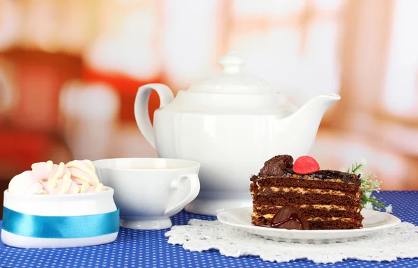 Bule, xícara de chá e bolo delicioso no fundo do quarto — Fotografia de Stock