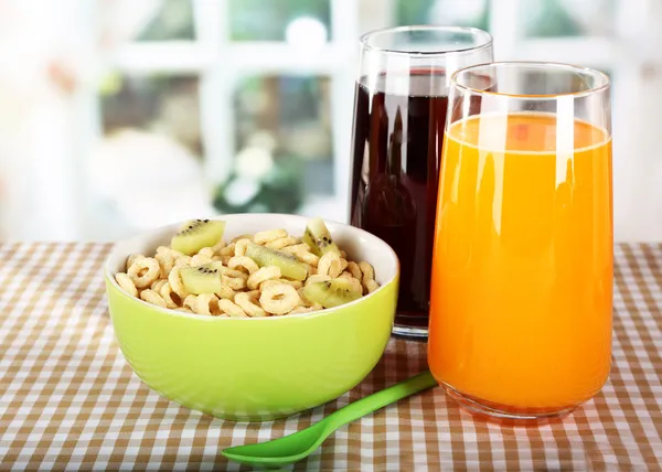 Deliziosi e sani cereali in ciotola con succo sul tavolo in camera — Foto Stock