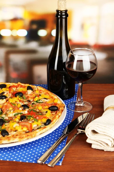 Tasty pizza with wine on wooden table on room background close-up — Stock Photo, Image