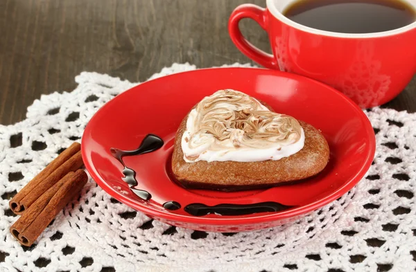 Шоколадное печенье в форме сердца с чашкой кофе на деревянном столе крупным планом — стоковое фото