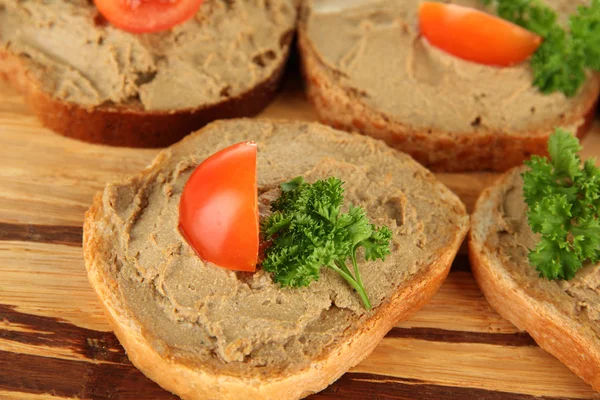 Fresh pate on bread on wooden board, close up — Stock Photo, Image