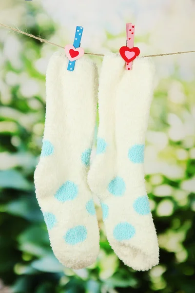 Colorful socks hanging on clothesline, on bright background — Stock Photo, Image