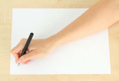 ahşap zemin üzerinde beyaz kağıt kalem ile el