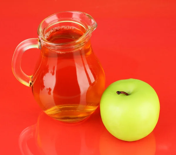 Jarra llena de jugo de manzana y manzana sobre fondo de color —  Fotos de Stock