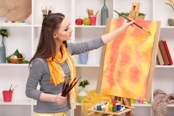 Beautiful young woman painter at work, on room interior background — Stock Photo, Image