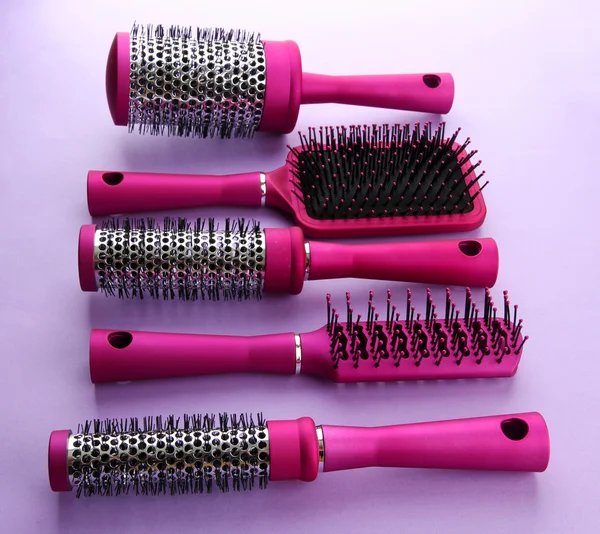 Comb brushes on purple background — Stock Photo, Image