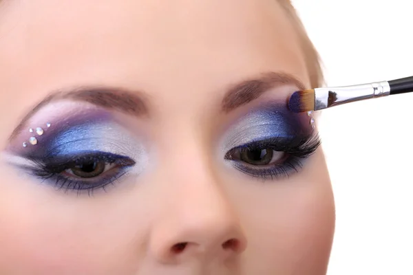 Hermosos ojos femeninos con maquillaje y cepillo azul brillante — Foto de Stock
