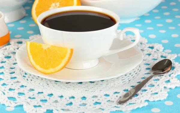 Beautiful white dinner service with oranges on blue tablecloth close-up — Stock Photo, Image