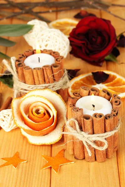 Rosa decorativa da casca de laranja seca e velas em chamas na mesa de madeira — Fotografia de Stock