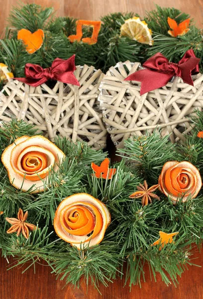 Corona de Navidad decorada con rosa de cáscara de naranja seca en la mesa de madera — Foto de Stock