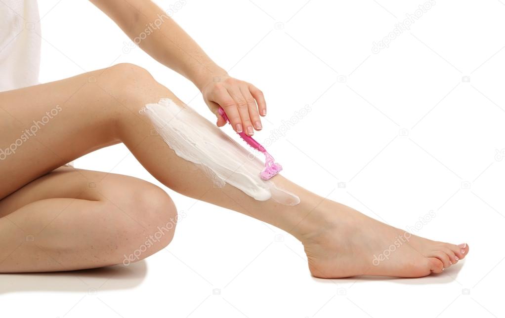 Beautiful woman is shaving her leg, isolated on white