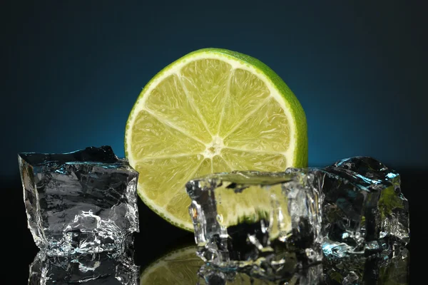 Ice cubes with lime on darck blue background — Stock Photo, Image