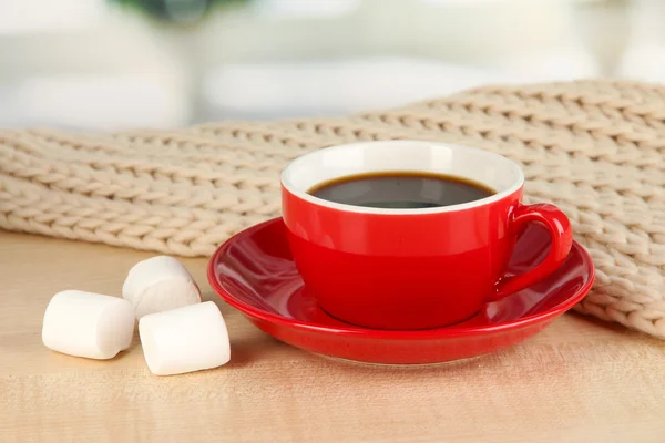 Tasse de café avec écharpe sur la table dans la chambre — Photo