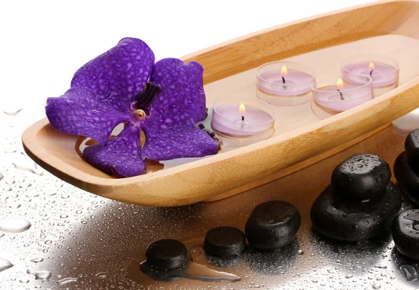 Spa pietre e ciotola di legno con candele e fiore viola, su sfondo bagnato — Foto Stock