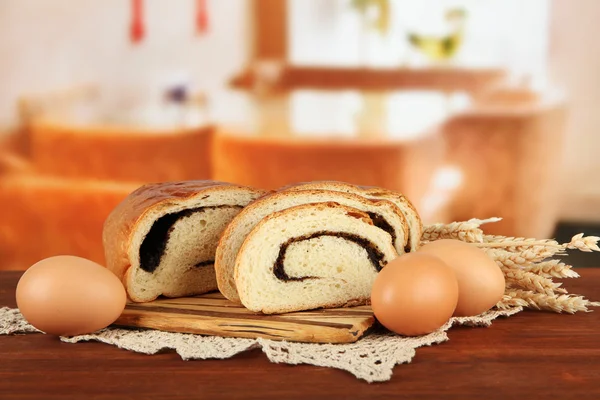 Loaf with poppy seed on cutting board, on bright background — Stock Photo, Image