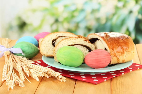 Loaf with poppy seeds on color plate, on bright background — Stock Photo, Image