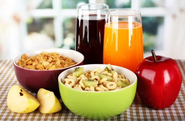 Delicious and healthy cereal in bowls with juice and fruit on table in room — Stock Photo, Image