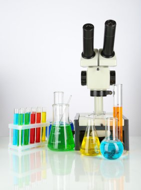 test tüpleri ile renkli sıvılar ve üzerinde beyaz izole mikroskobu