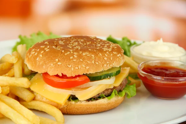 Вкусный чизбургер с жареной картошкой, на ярком фоне — стоковое фото