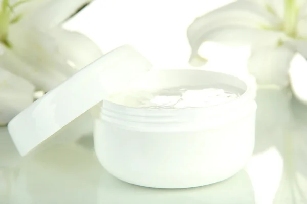 Crema cosmética y hermoso lirio, aislado en blanco — Foto de Stock