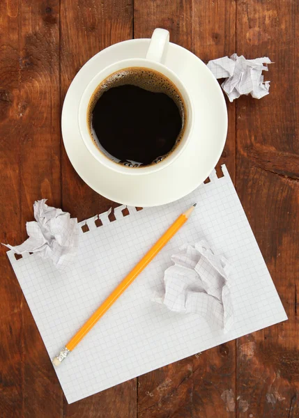 Cup of coffee on worktable covered with documents close up — Stock Photo, Image