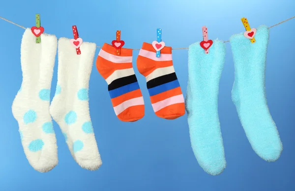Kleurrijke sokken opknoping op/droogmolen, op een achtergrond met kleur — Stockfoto