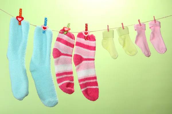Calcetines coloridos colgando en el tendedero, sobre fondo de color — Foto de Stock
