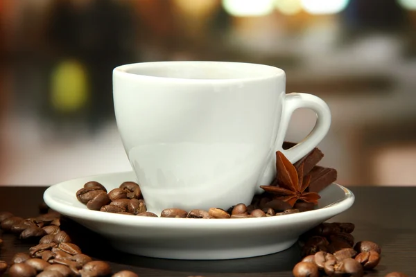 Cup of coffee with beans on table in cafe — Stock Photo, Image