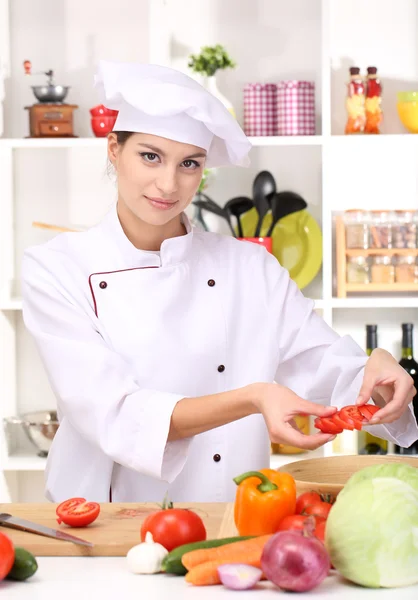 Young woman chef cooking in kitchen — Stock Photo, Image