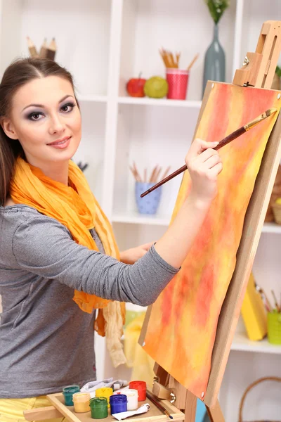 Mooie jonge vrouw schilder op het werk, op kamer interieur achtergrond — Stockfoto