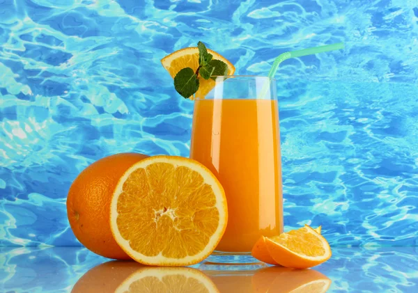 Copo de suco de laranja com hortelã e laranja no fundo do mar — Fotografia de Stock