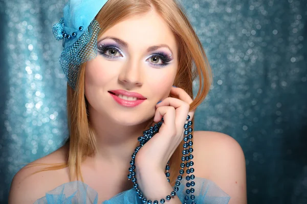 Portret pięknej młodej kobiety z seksowny makijaż, na niebieskim tle — Zdjęcie stockowe