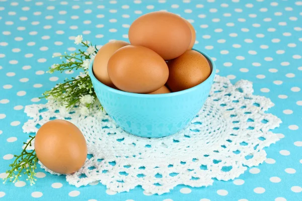 Eggs in bowl on blue tablecloth close-up — Stock Photo, Image
