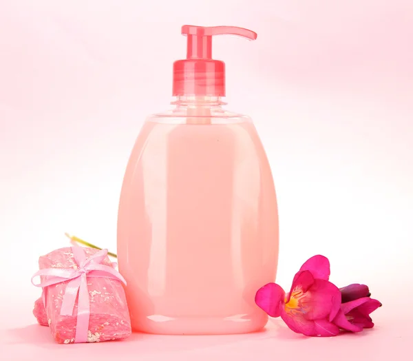Sabonetes líquidos e feitos à mão sobre fundo rosa — Fotografia de Stock