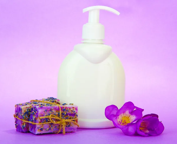 Liquid and hand-made soaps on purple background — Stock Photo, Image