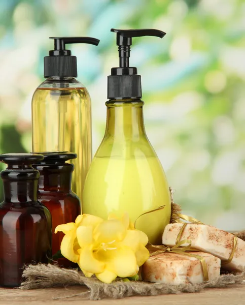 Жидкое и ручное мыло на деревянном столе, на зеленом фоне — стоковое фото