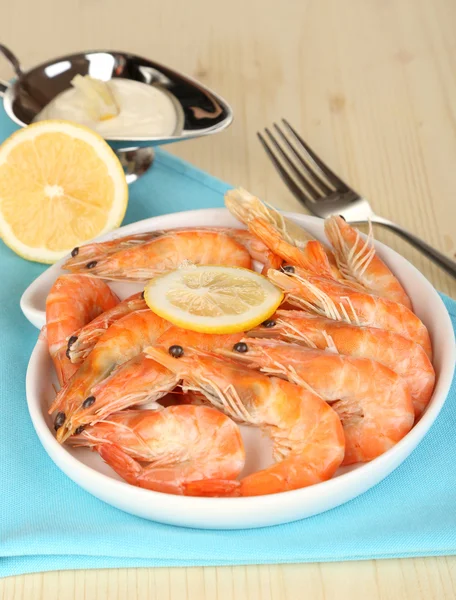Shrimps with lemon on plate on wooden table close-up — Stock Photo, Image