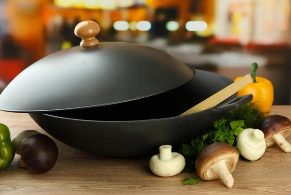 Poêle wok noir et légumes sur table en bois de cuisine, gros plan — Photo