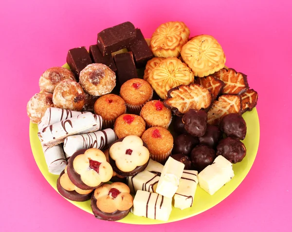 Galletas dulces en plato sobre fondo rosa —  Fotos de Stock